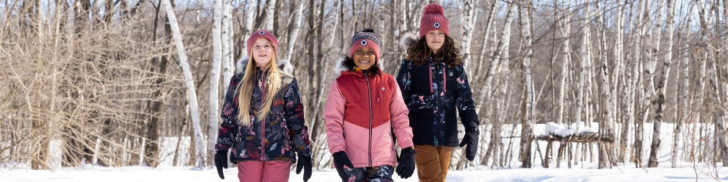 3 enfants fille qui avec un manteau rose et noir et des tuques colorés