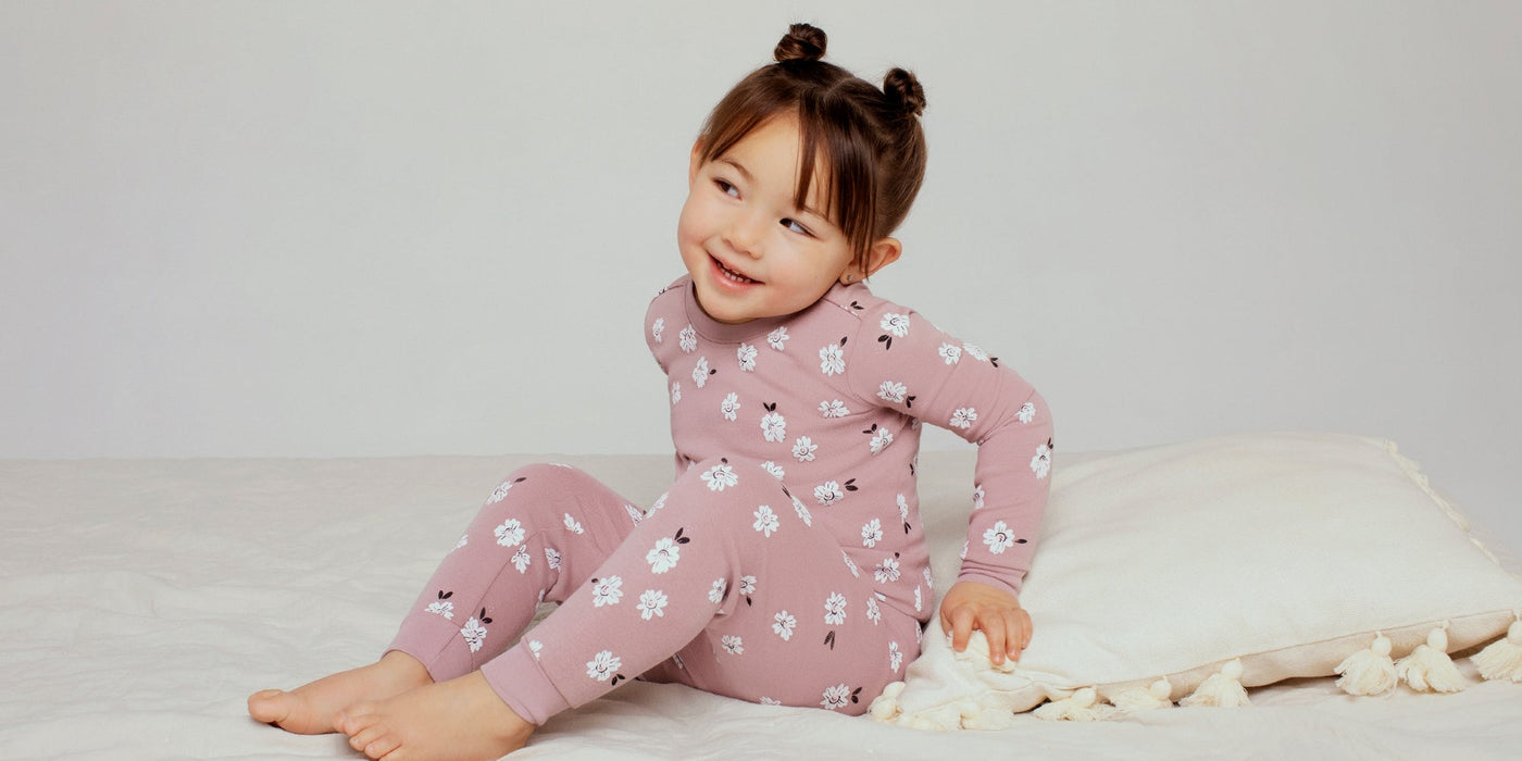 une petite fille portant un pyjama petit lem rose 