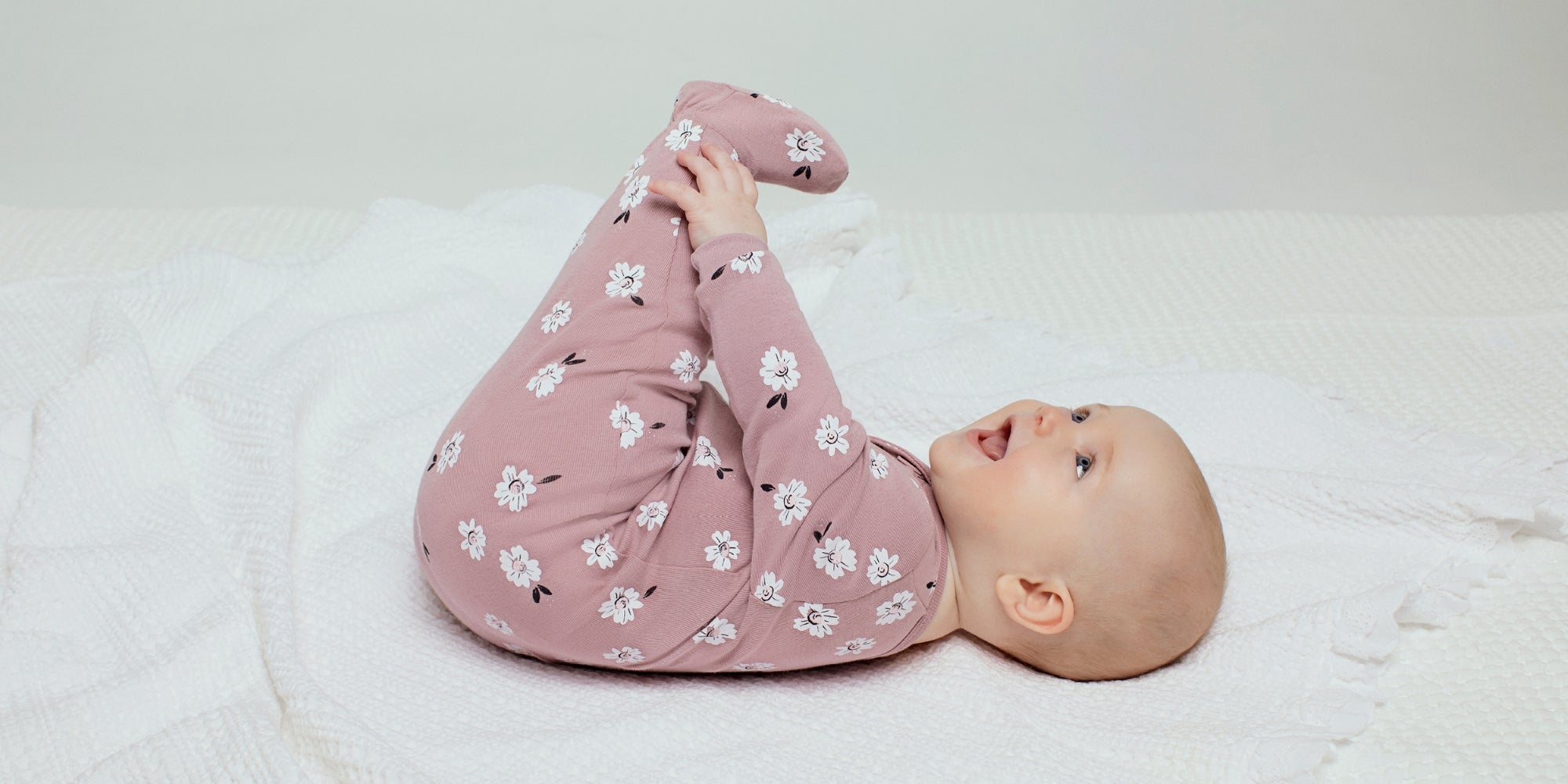 Un bébé fille couché sur le dos avec un vêtement petit lem